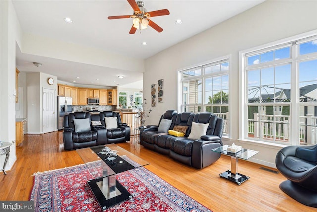 living room featuring light hardwood / wood-style flooring and ceiling fan