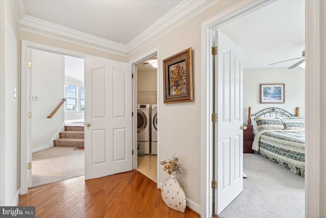 hall featuring crown molding, hardwood / wood-style floors, and independent washer and dryer