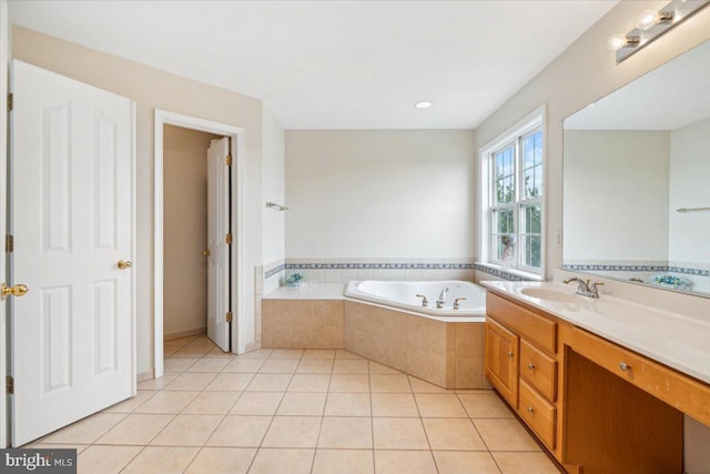 bathroom featuring vanity, tiled tub, and tile patterned flooring