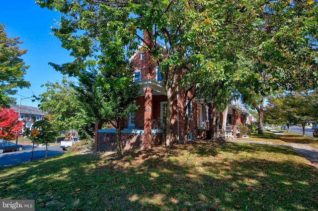 multi unit property featuring a front lawn and brick siding