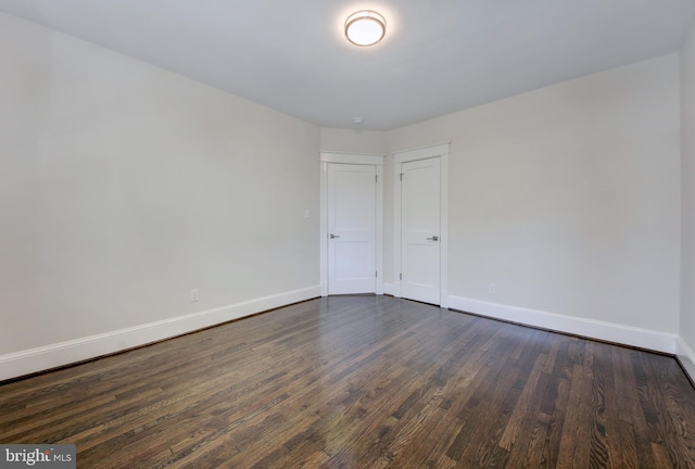 unfurnished room featuring dark wood-type flooring