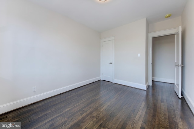 unfurnished bedroom with a closet and dark hardwood / wood-style flooring