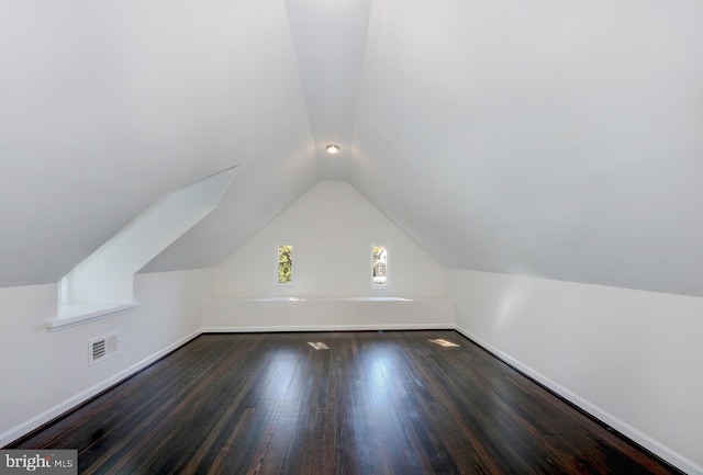 bonus room with dark wood-type flooring and lofted ceiling