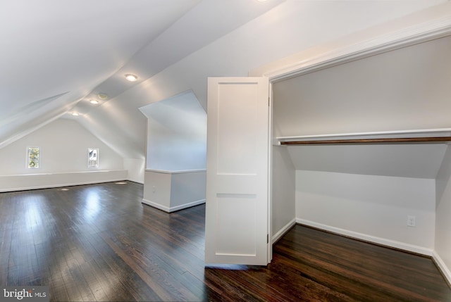 additional living space with dark wood-type flooring and lofted ceiling