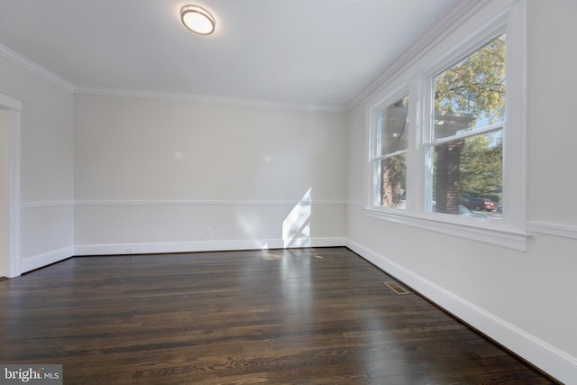 empty room with dark hardwood / wood-style floors and crown molding