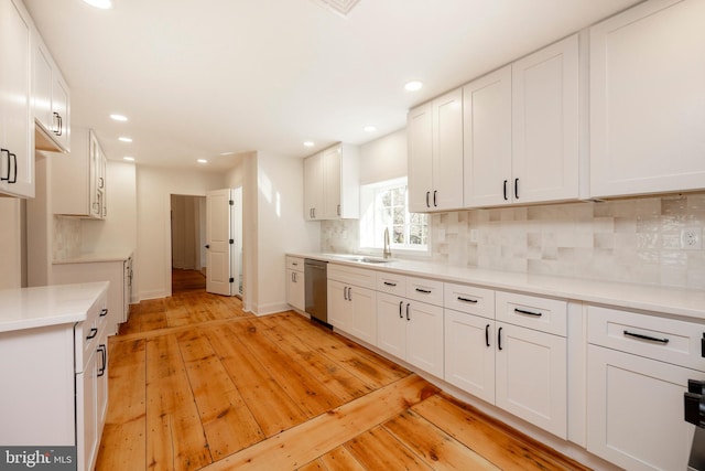 kitchen with backsplash, light wood-type flooring, and white cabinets