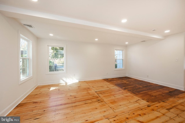 empty room featuring a healthy amount of sunlight and light hardwood / wood-style floors