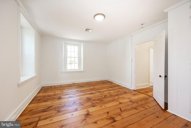 spare room with ornamental molding and light hardwood / wood-style flooring