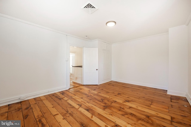 unfurnished room featuring wood-type flooring and ornamental molding