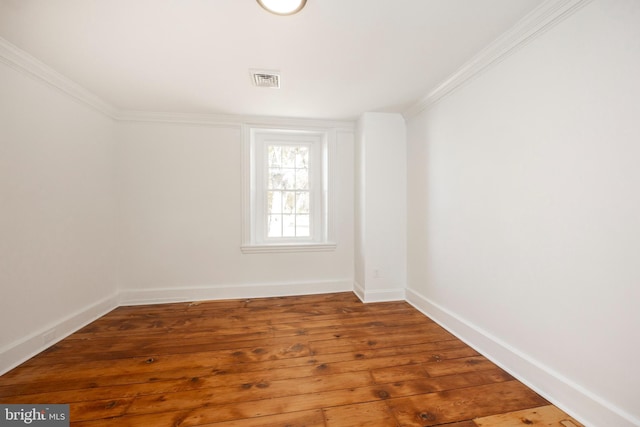 spare room with crown molding and hardwood / wood-style floors