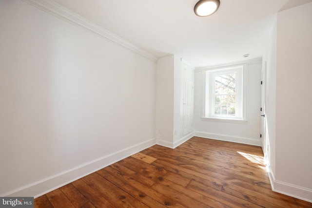 spare room with ornamental molding and hardwood / wood-style floors