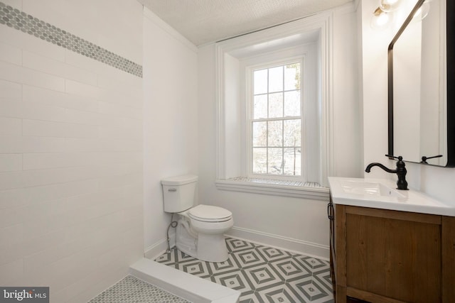 bathroom with vanity, toilet, a textured ceiling, and tile patterned flooring