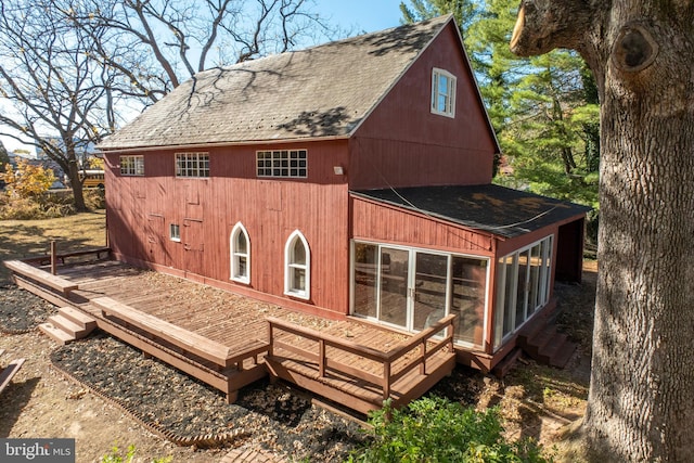 back of house featuring a sunroom and a deck