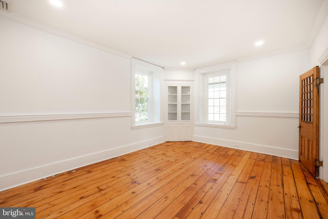 spare room with crown molding and light hardwood / wood-style flooring