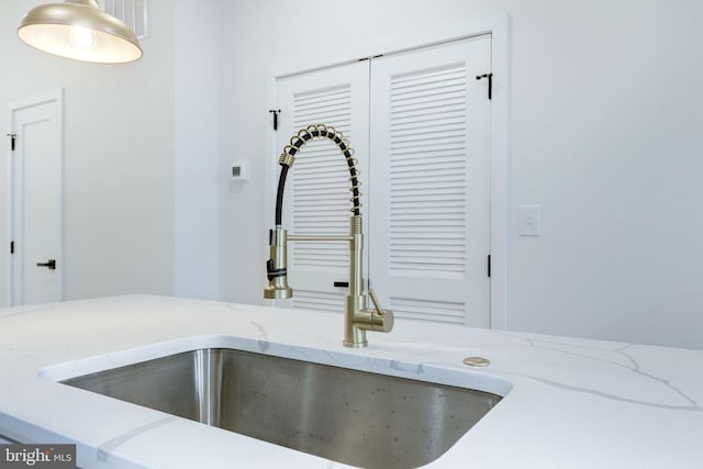 details featuring light stone countertops and sink