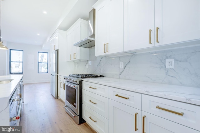 kitchen with stainless steel appliances, backsplash, hanging light fixtures, light hardwood / wood-style floors, and white cabinets