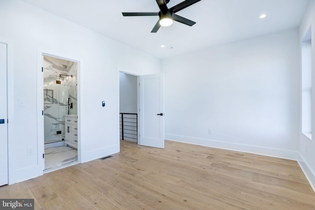 unfurnished bedroom featuring light hardwood / wood-style floors, ceiling fan, and connected bathroom