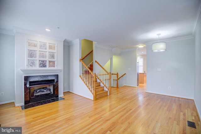 living room with ornamental molding, light wood-type flooring, and a fireplace