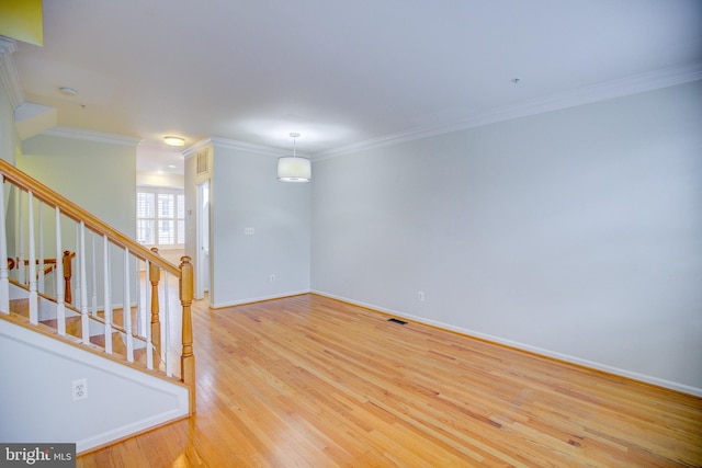 empty room featuring crown molding and light hardwood / wood-style floors