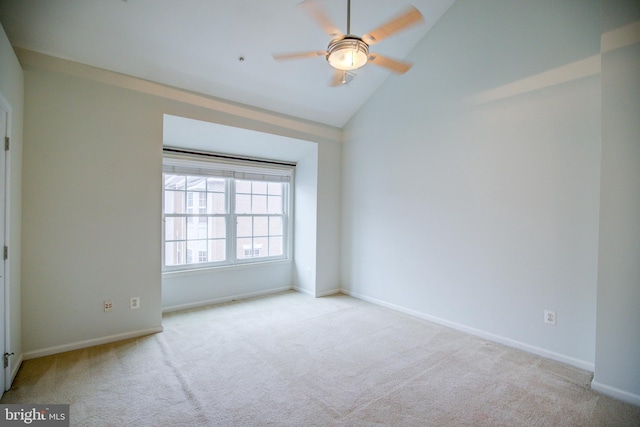 carpeted spare room featuring ceiling fan and lofted ceiling