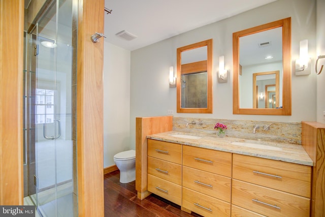 bathroom with toilet, an enclosed shower, vanity, and wood-type flooring