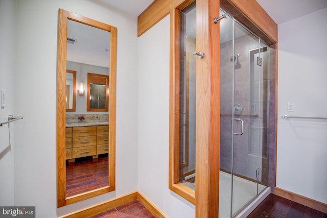 bathroom with vanity, wood-type flooring, and an enclosed shower