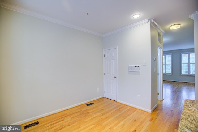 empty room with ornamental molding and light wood-type flooring