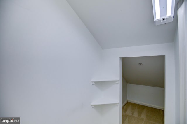 interior space featuring carpet flooring and vaulted ceiling