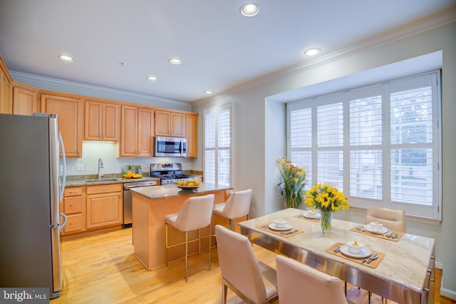 kitchen featuring a center island, a healthy amount of sunlight, stainless steel appliances, and sink