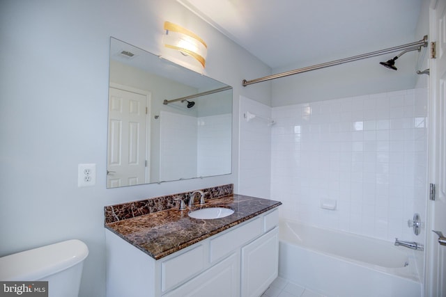 full bathroom with toilet, tiled shower / bath, vanity, and tile patterned flooring