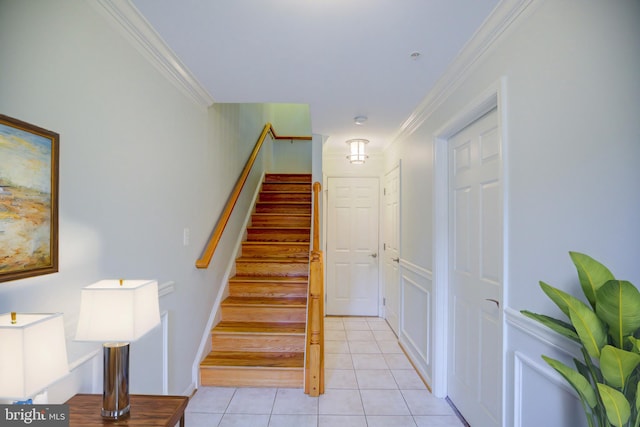 stairs with crown molding and tile patterned floors