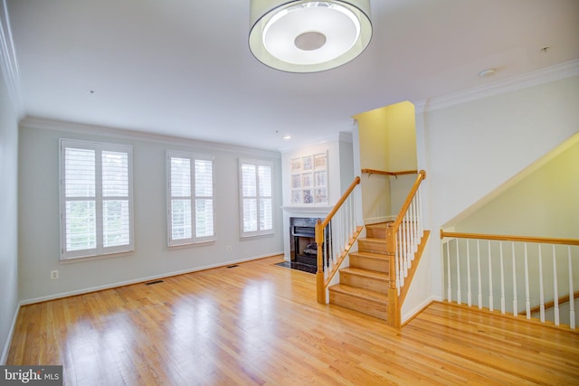 interior space featuring ornamental molding, a fireplace, and wood-type flooring