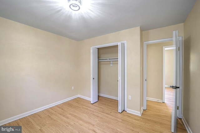 unfurnished bedroom featuring a closet and light hardwood / wood-style floors