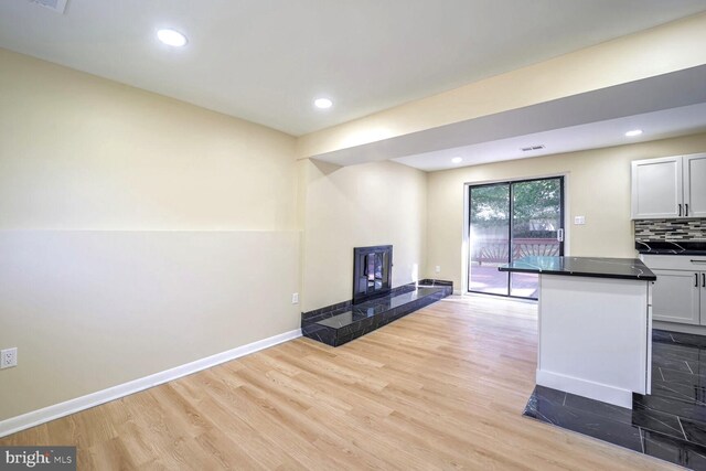 kitchen with decorative backsplash, light hardwood / wood-style flooring, and white cabinets