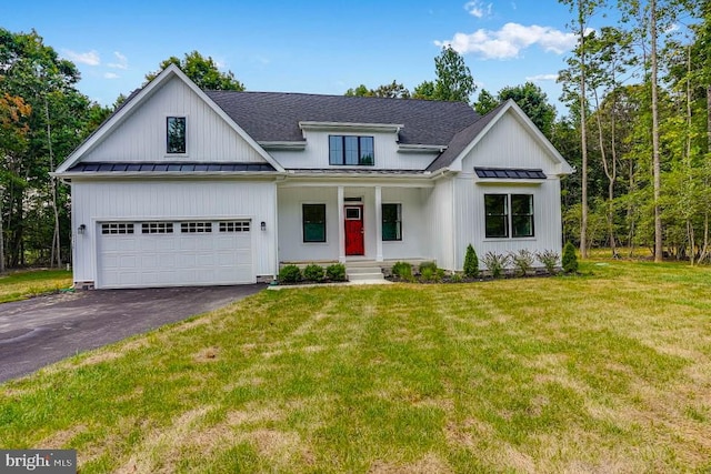 modern inspired farmhouse with a front yard, a garage, and covered porch