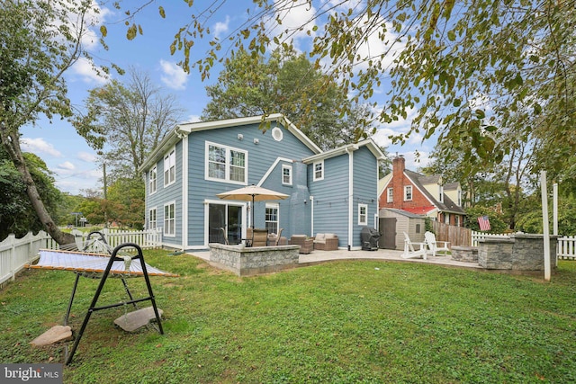 rear view of house featuring a patio area and a lawn