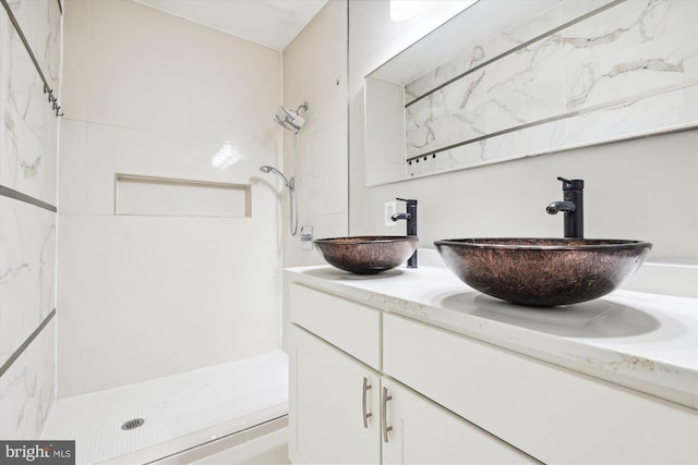 bathroom with vanity and a tile shower