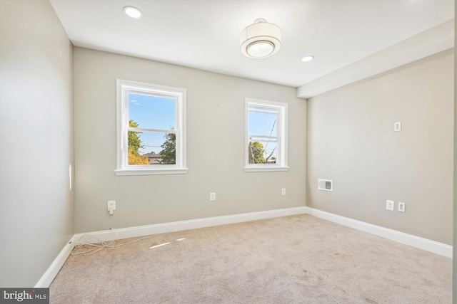 unfurnished room featuring carpet and a wealth of natural light