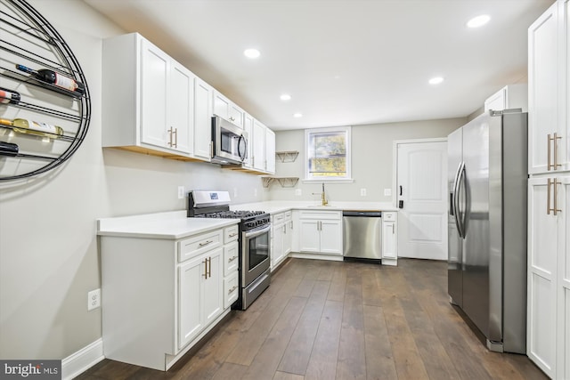 kitchen with dark wood-type flooring, appliances with stainless steel finishes, sink, and white cabinets