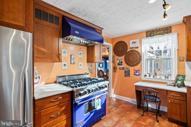 kitchen with light tile patterned flooring, custom range hood, stainless steel appliances, and track lighting