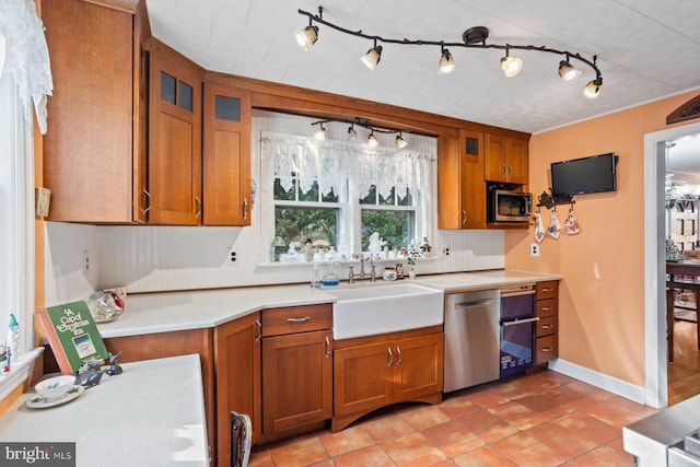 kitchen with appliances with stainless steel finishes, sink, light tile patterned floors, and backsplash