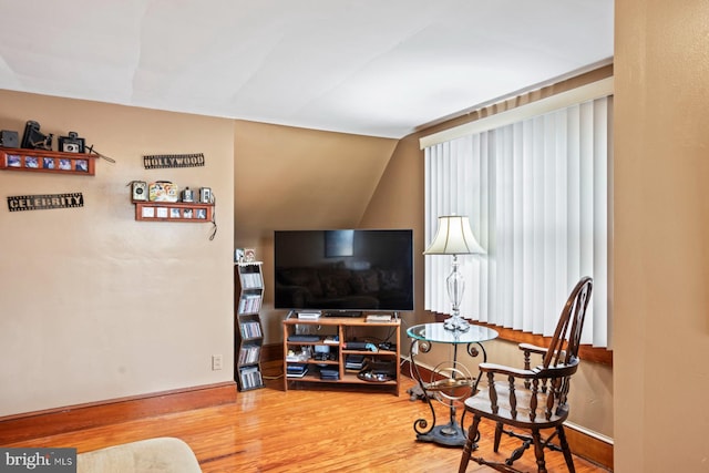 living area featuring vaulted ceiling and hardwood / wood-style flooring