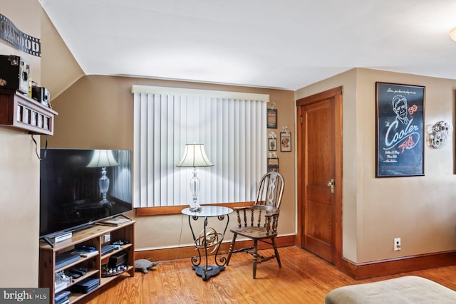 sitting room with hardwood / wood-style flooring and vaulted ceiling