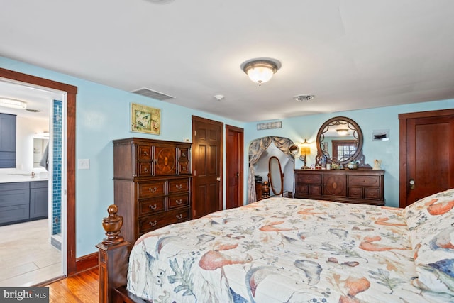 bedroom with light hardwood / wood-style flooring and connected bathroom