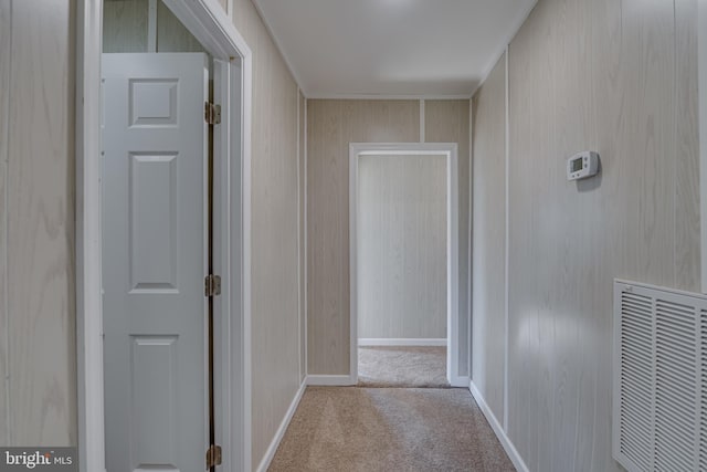 hall featuring wood walls and light colored carpet