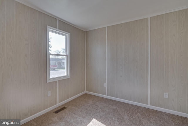 empty room with carpet and wood walls