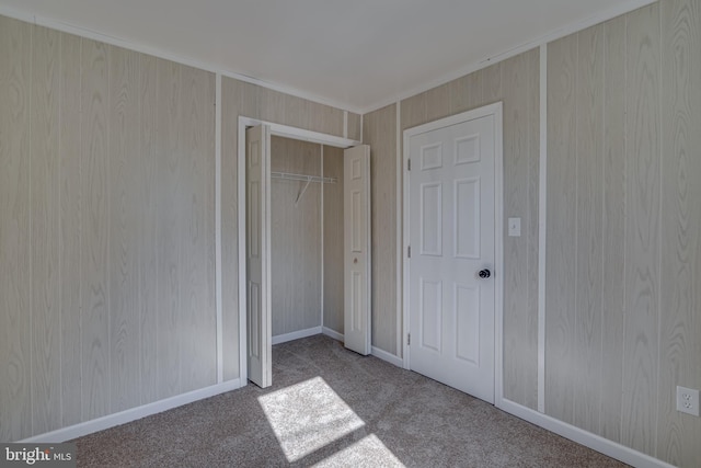 unfurnished bedroom with baseboards, a closet, and carpet flooring
