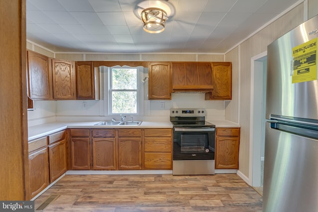 kitchen with crown molding, sink, light hardwood / wood-style flooring, and stainless steel appliances