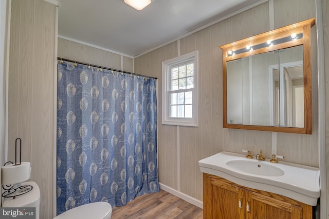 bathroom featuring a shower with curtain, vanity, toilet, ornamental molding, and wood finished floors