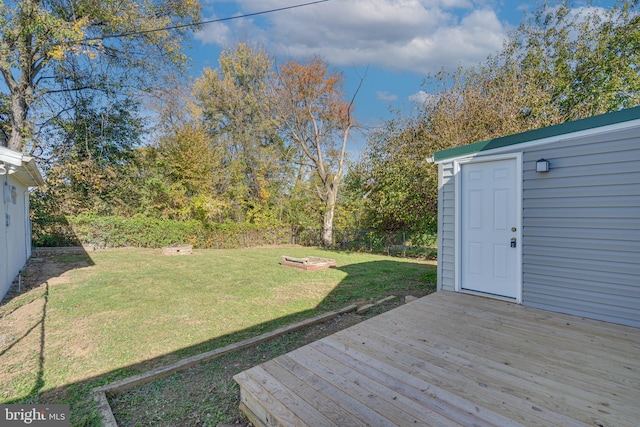 view of yard featuring fence, a wooden deck, and an outdoor structure